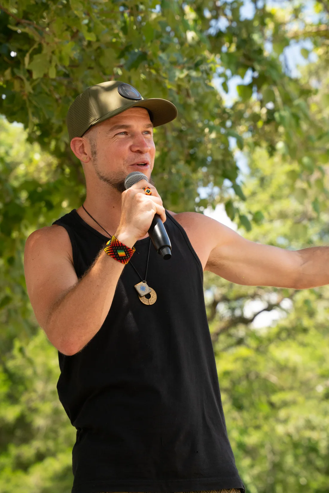 Tyzen on the mic at Declaration of Sovereignty, arm extended toward the circle