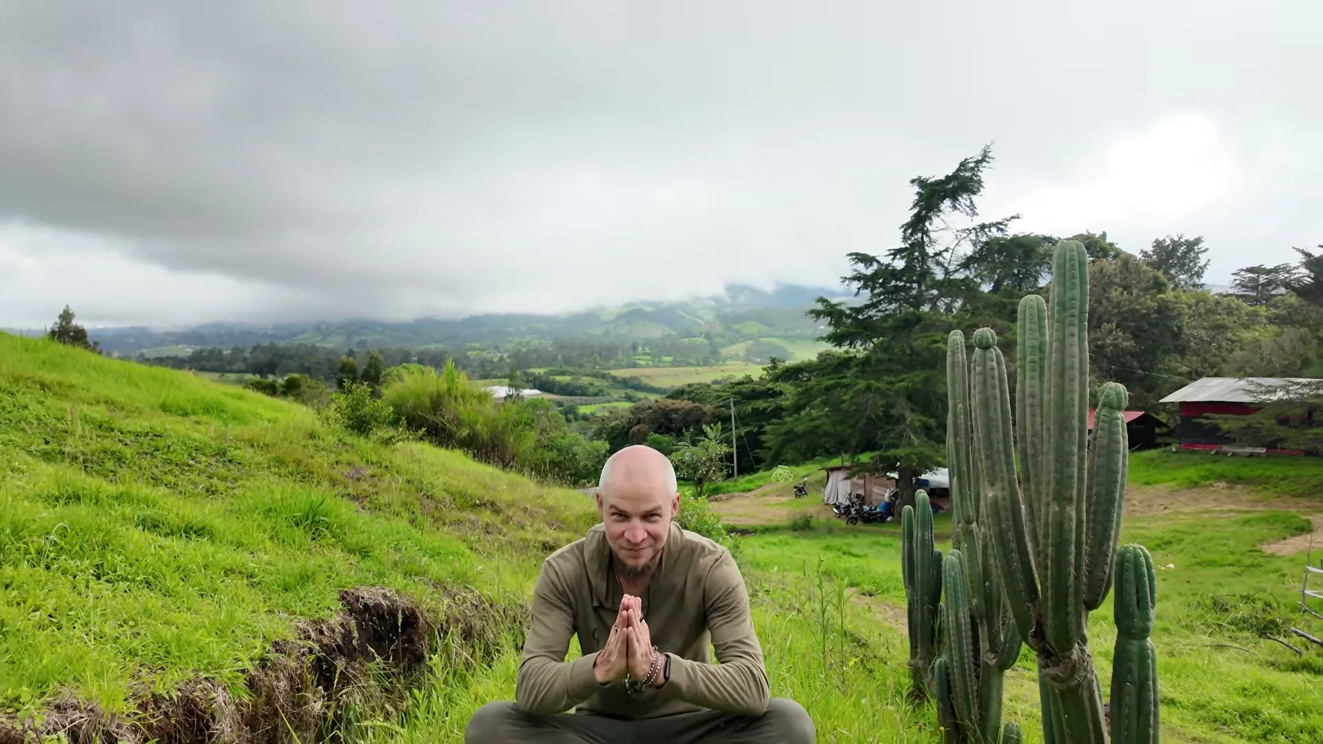 Tyzen on a hillside in Colombia, palms pressed together as the Prayer of Remembering closes