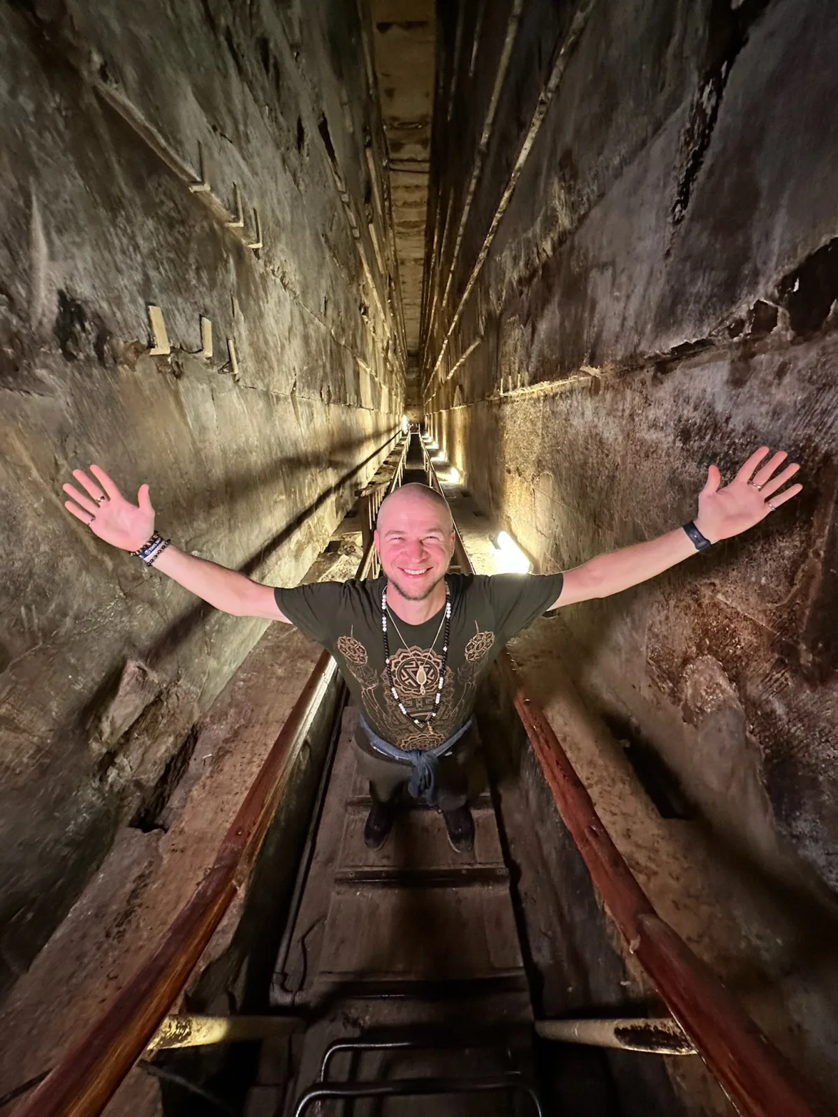 Tyler standing in a shaft of light inside an Egyptian temple, arms open