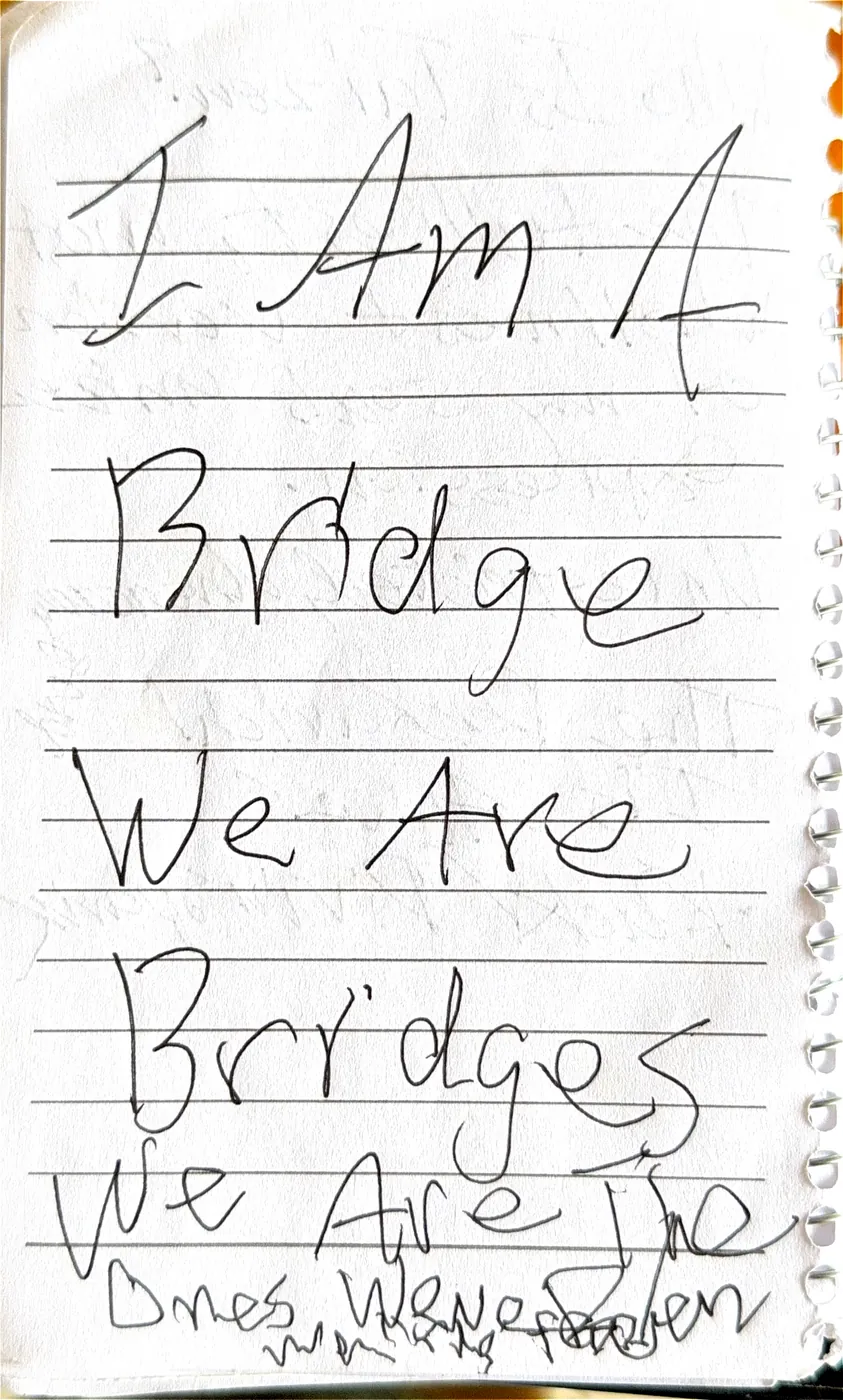 A journal page written in very large letters: I am a bridge, we are bridges, we are the ones we've been waiting for.