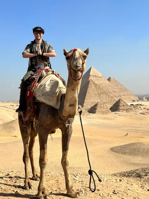 Tyler on a camel before the pyramids of Giza