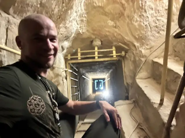 At the mouth of a lit tomb passage